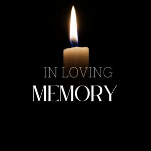 dark background behind a candle with flame and the words "in loving memory"
